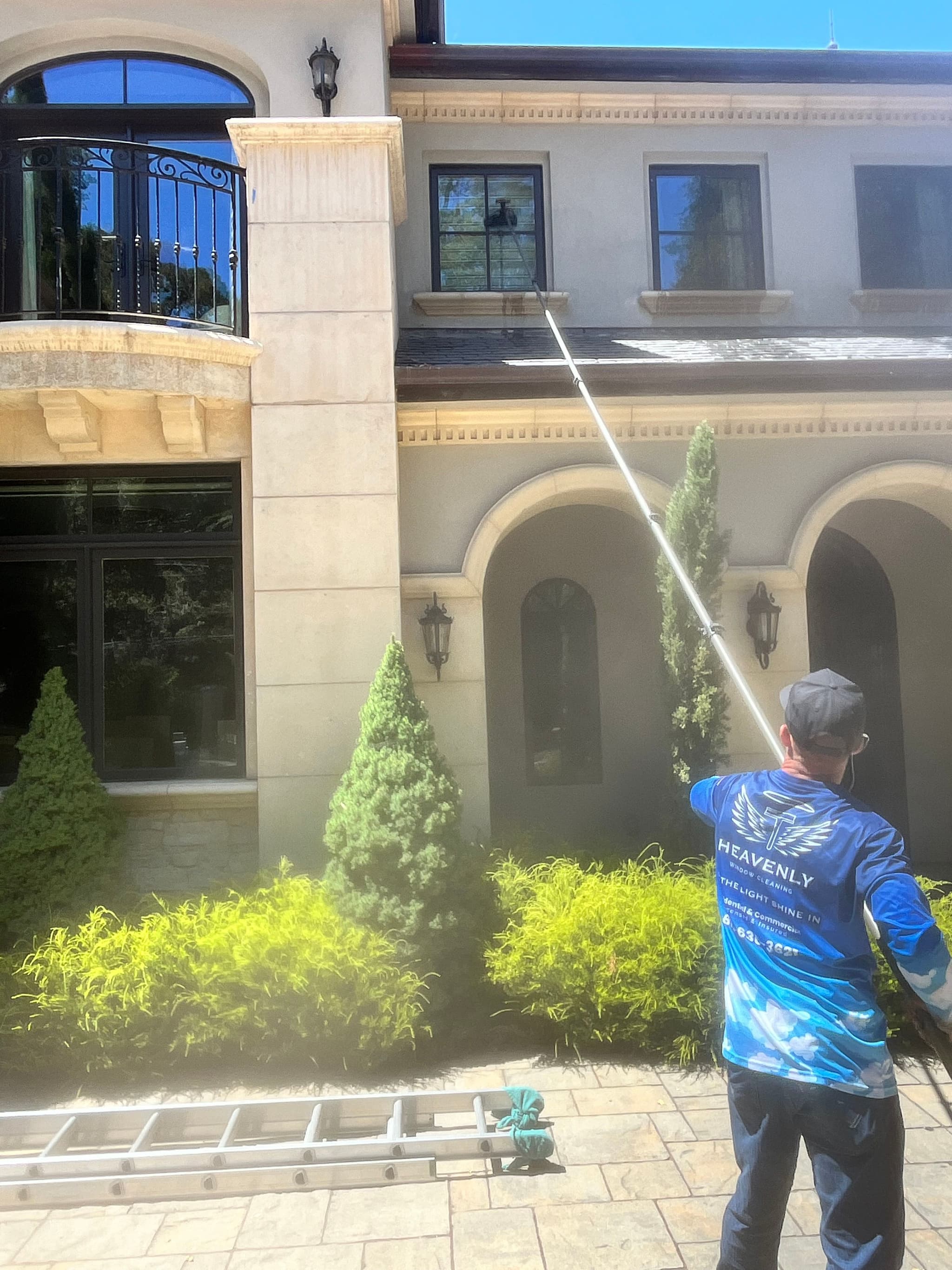 Technician working on a multi storey building with a water fed pole